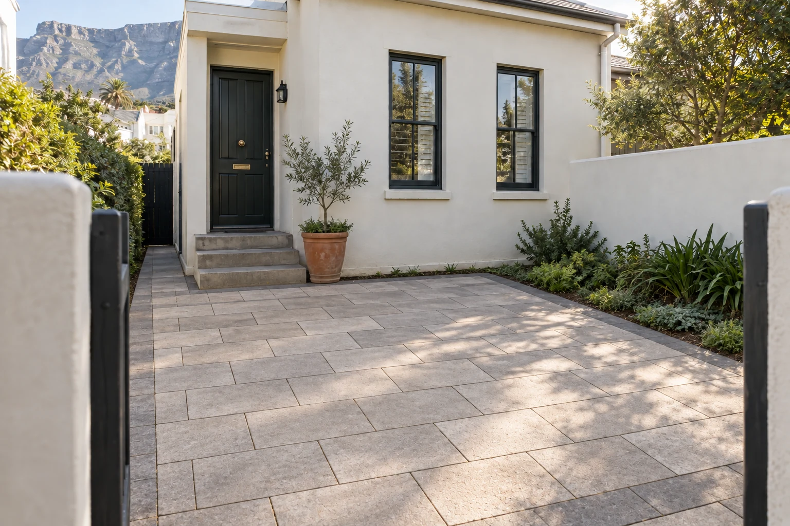 Generated after view of the same townhouse entrance court with warm grey pavers