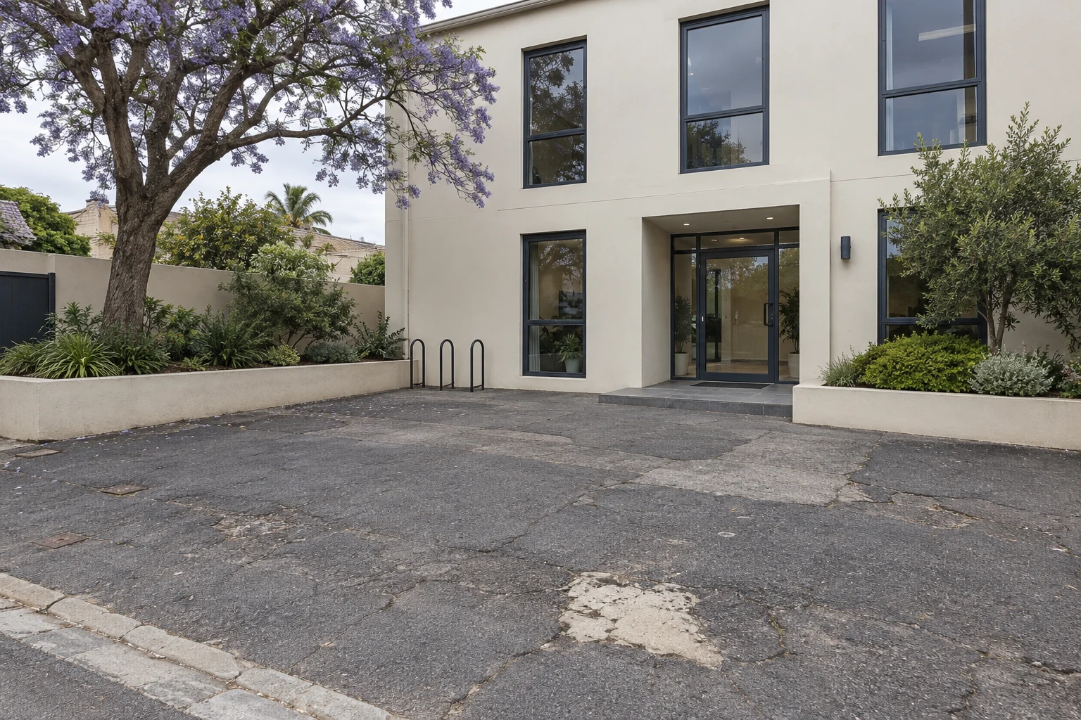 Generated view of a worn asphalt forecourt at a fictional office