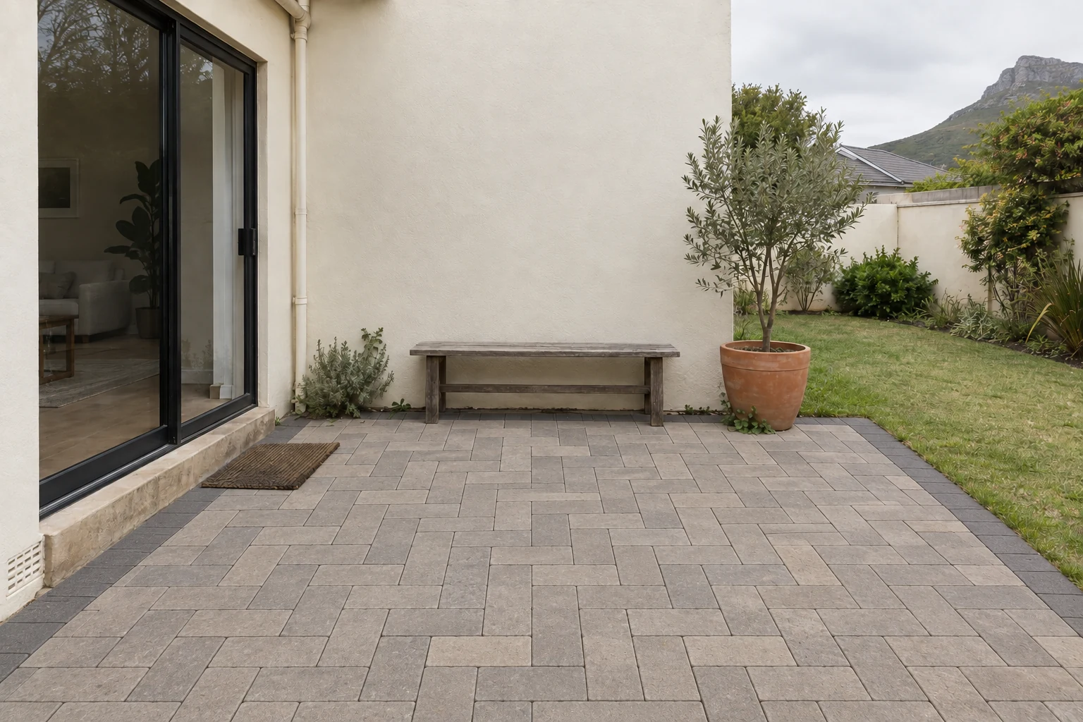 Generated view of the same fictional patio with warm grey paving slabs