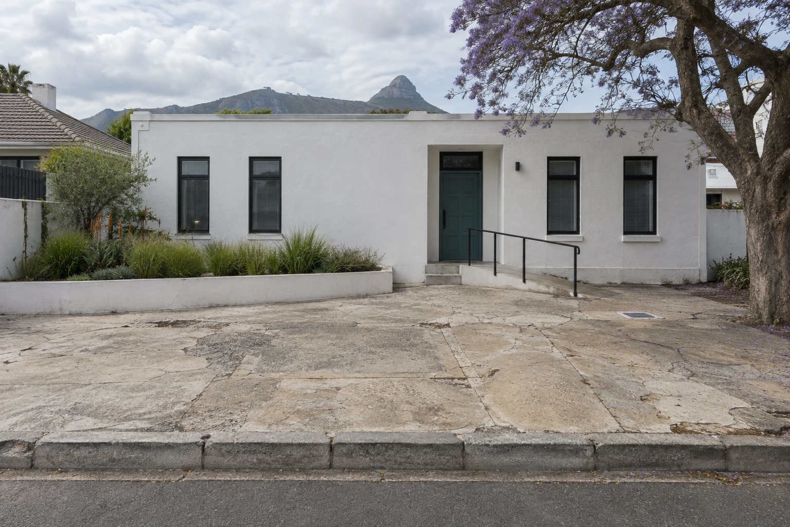 Generated before view of a worn concrete forecourt outside a fictional Cape Town practice