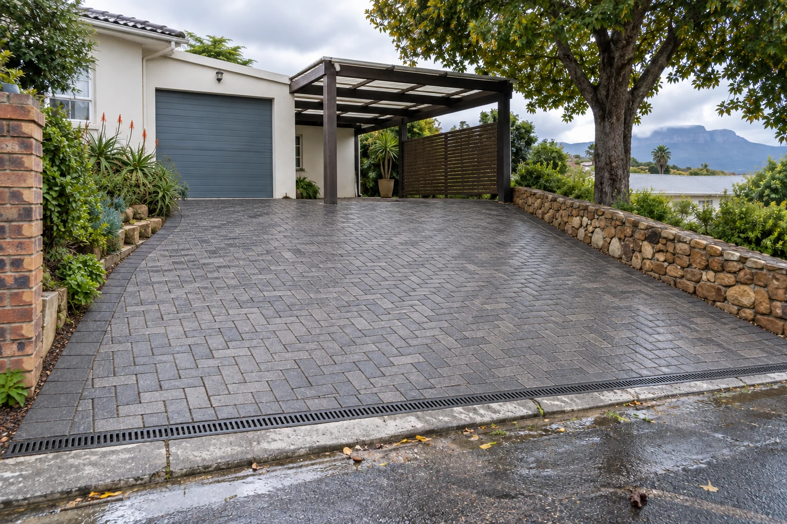 Generated after view of the same sloped driveway with charcoal interlocking paving and a channel drain