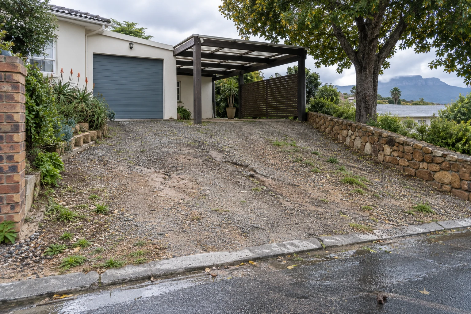 Generated before view of a gravel driveway sloping to a fictional Cape Town home